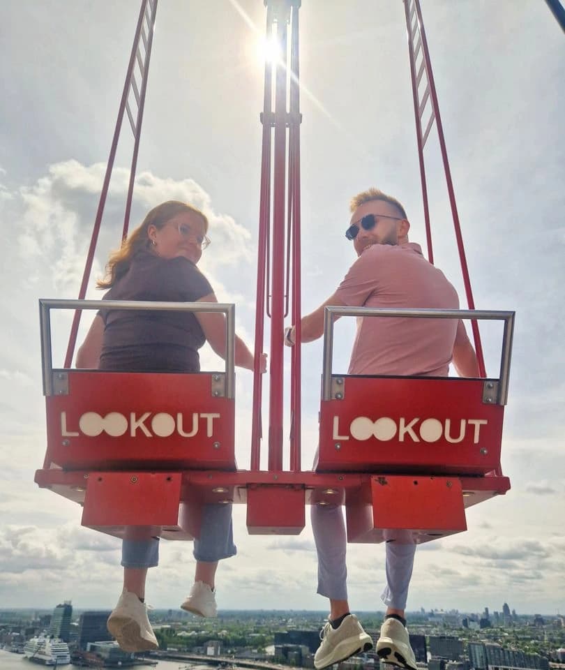 Rachel and Reid on a swing over the edge of a tower high above Amsterdam